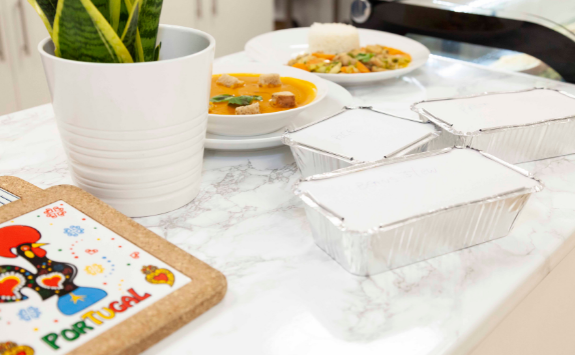 Cooked meals and takeaway boxes sit on the counter in the cafe, Goreti